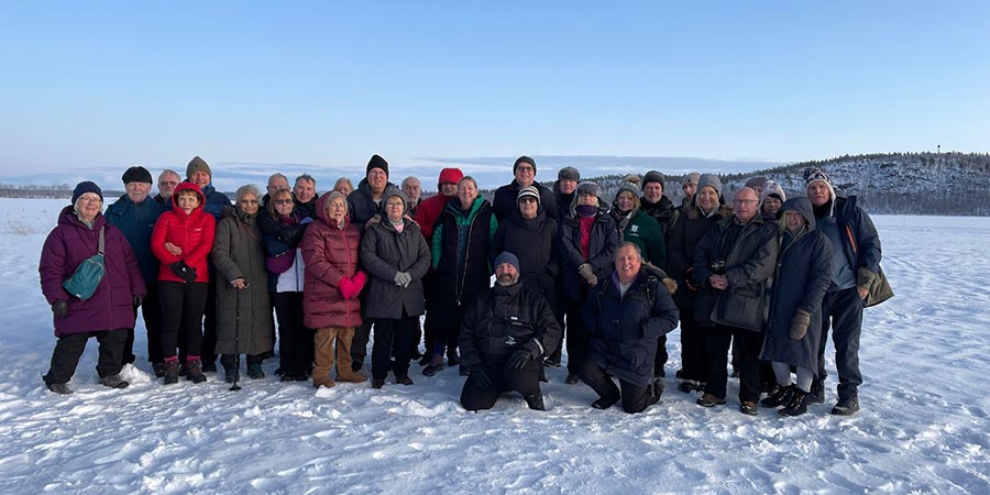 A group of Great Rail Journeys customers have their photo taken by the Russian border. 